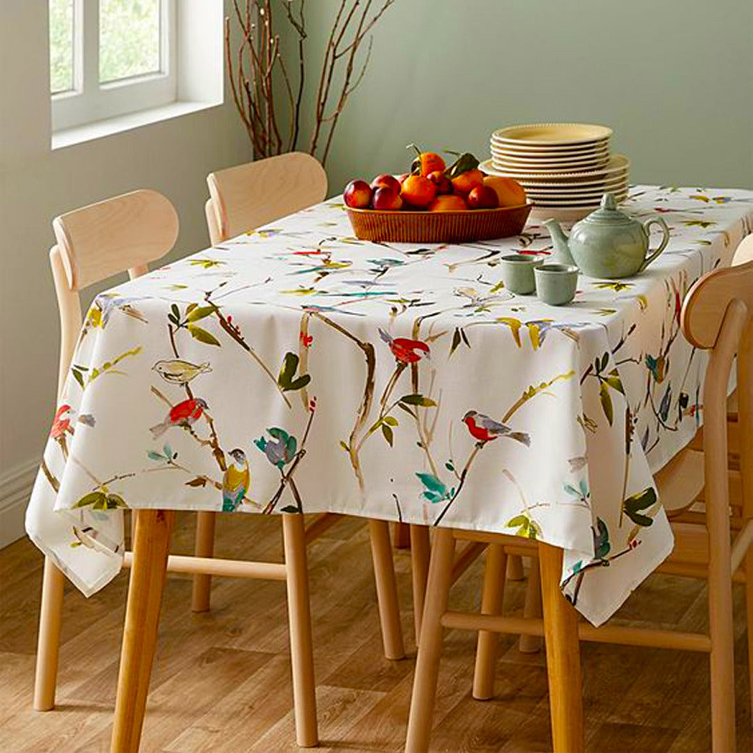 Cream tablecloth with colourful birds and delicate branch motifs.