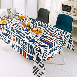 Black and white abstract line-pattern tablecloth with small coloured accents.
