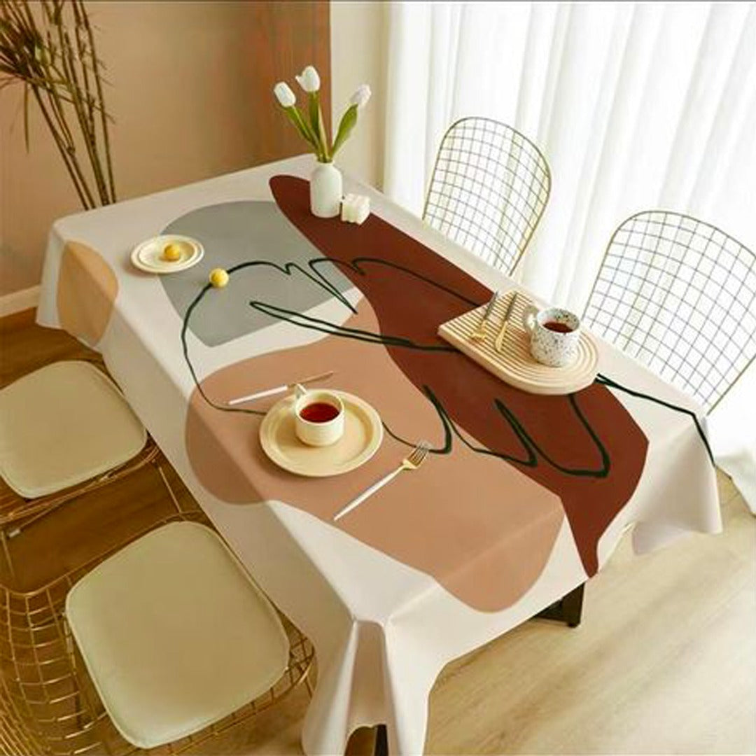 Tablecloth with a large abstract face design in cream, brown and peach.