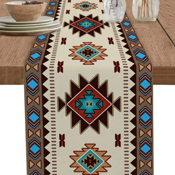 Close-up of a cream table runner with red, turquoise and black diamond motifs.