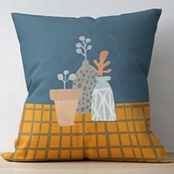 Blue cushion cover with three flower vases on a mustard grid-patterned table.