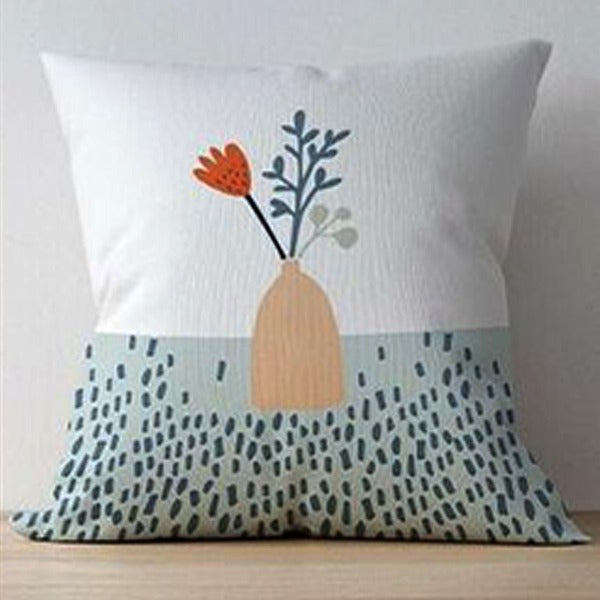 White cushion cover with a flower vase above a pale blue speckled panel.