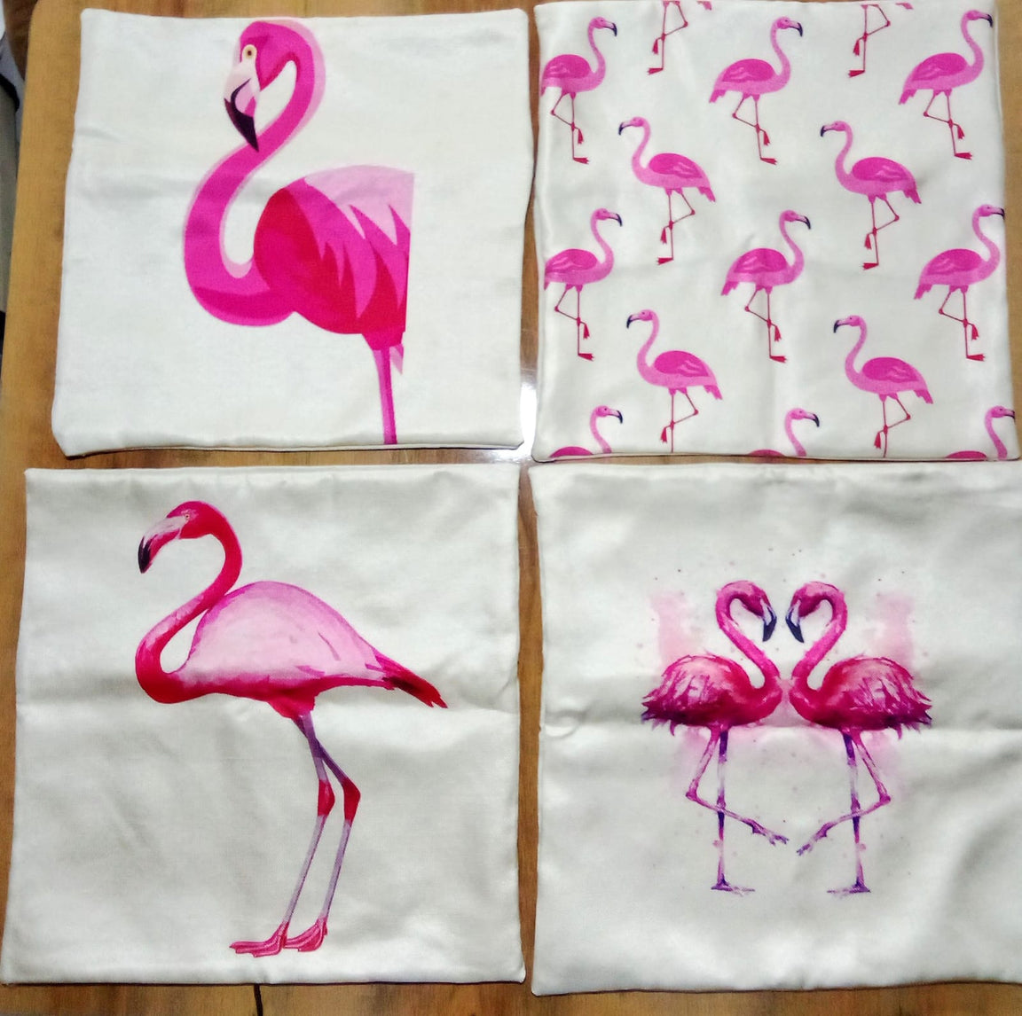 Four flamingo cushion covers laid flat to show their different pink bird designs.