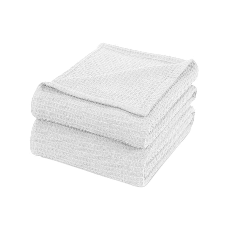 Folded white waffle-weave cotton thermal blanket.