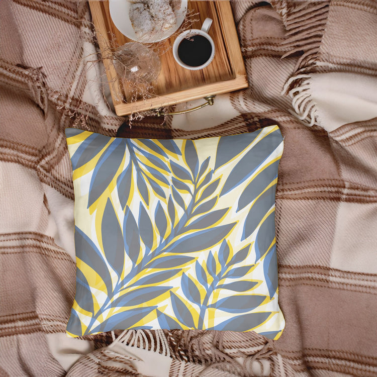 Grey cushion cover with pale yellow and cream leafy stems.