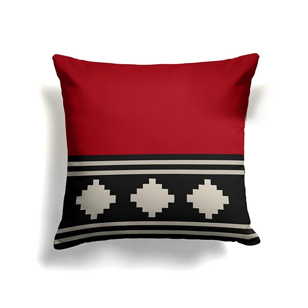 Red cushion cover with black and cream horizontal bands and three cream diamonds.