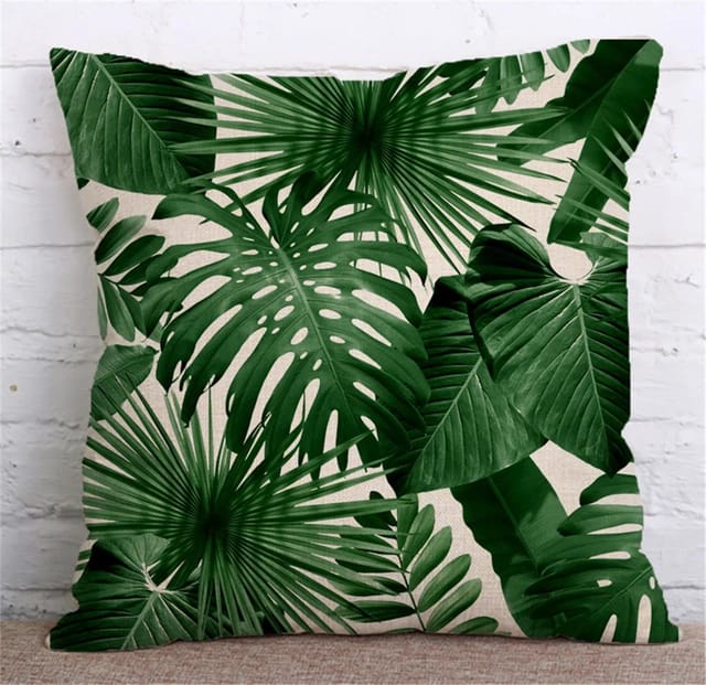 Cushion cover with dense overlapping dark green tropical leaves.