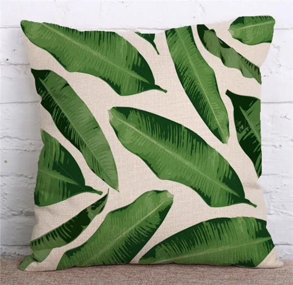 Cream cushion cover with large diagonal green banana leaves.