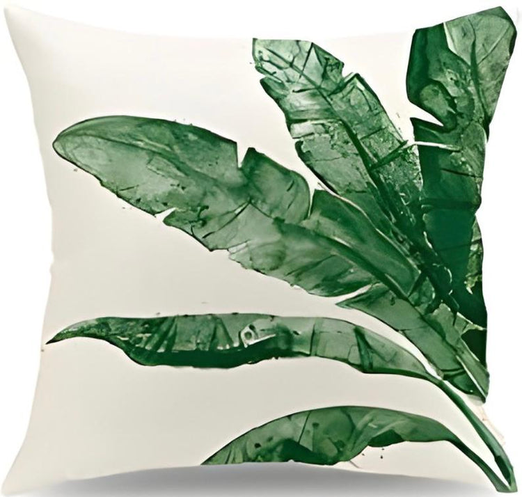 Cream cushion cover with long green leaves spreading diagonally.