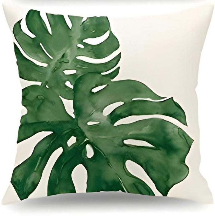Cream cushion cover with two large green monstera leaves.
