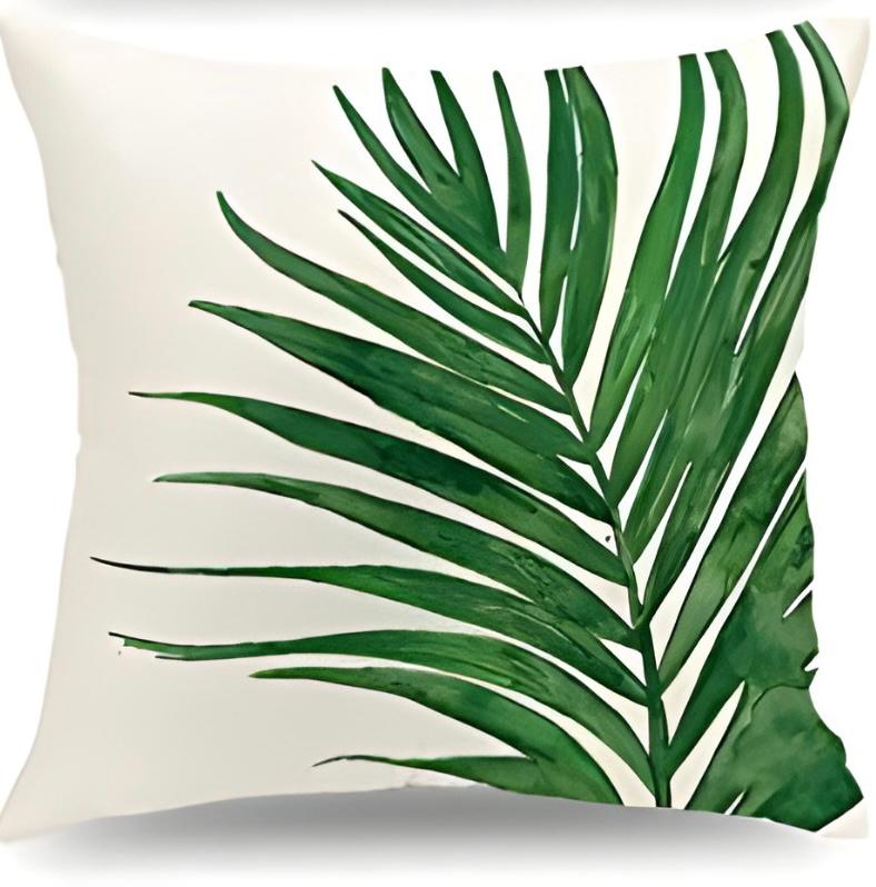 Cream cushion cover with a large curved green palm frond.