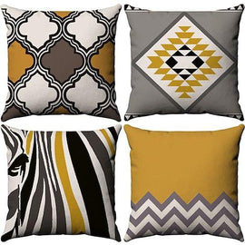 Four mustard, grey, black and white cushion covers with mixed geometric patterns.