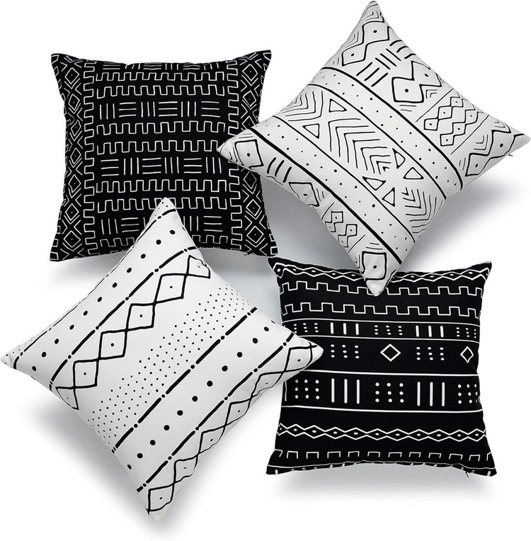 Four black and white cushion covers with hand-drawn geometric line patterns.