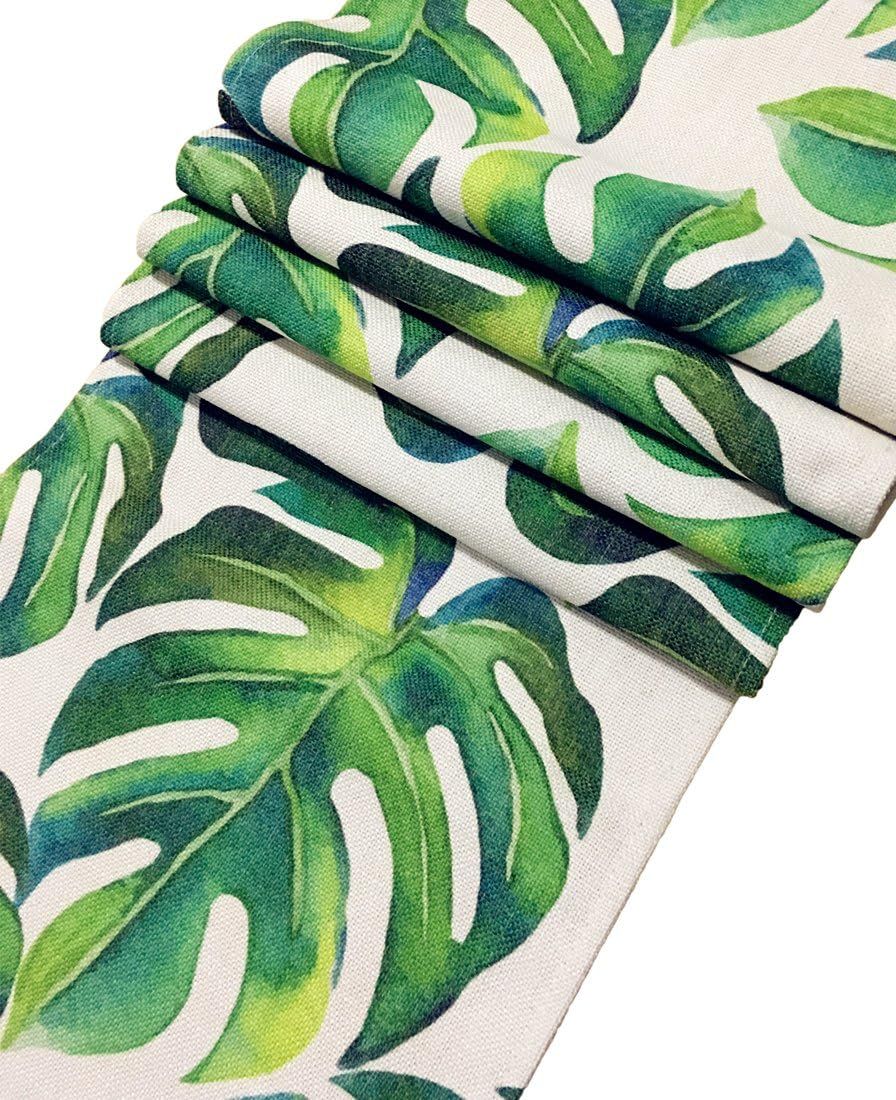 Close-up of folded green tropical-leaf table-runner fabric.