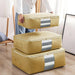 Mustard zippered clothes-storage bags stacked beside a person holding one bag.