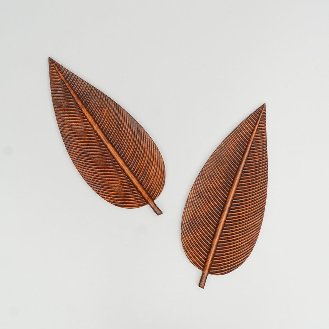 Two brown leaf-shaped trays arranged diagonally on a white background