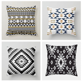 Four cushion covers with black, white, navy and gold coloured geometric patterns.