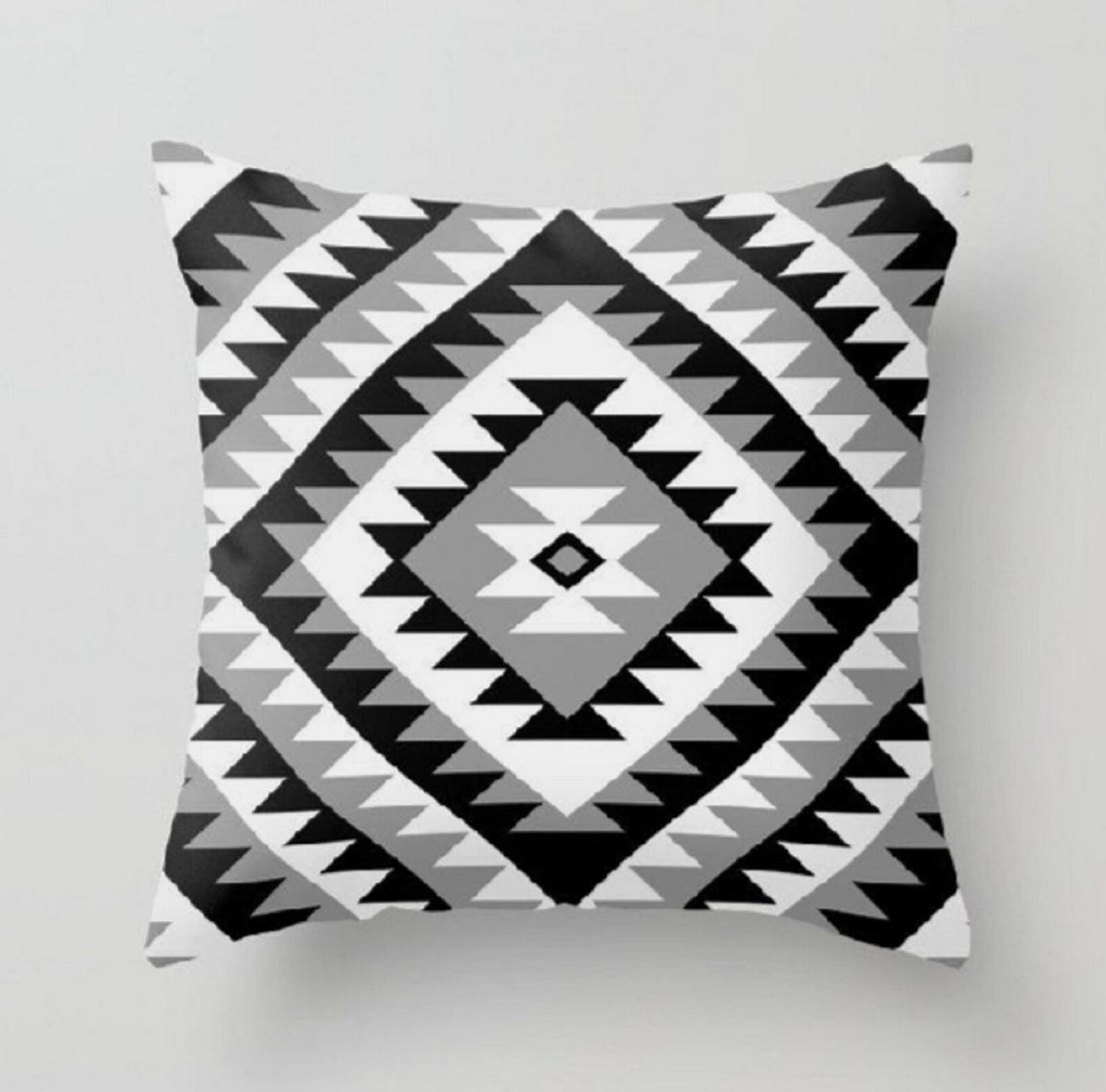 Cushion cover with nested black, grey and white stepped diamonds.