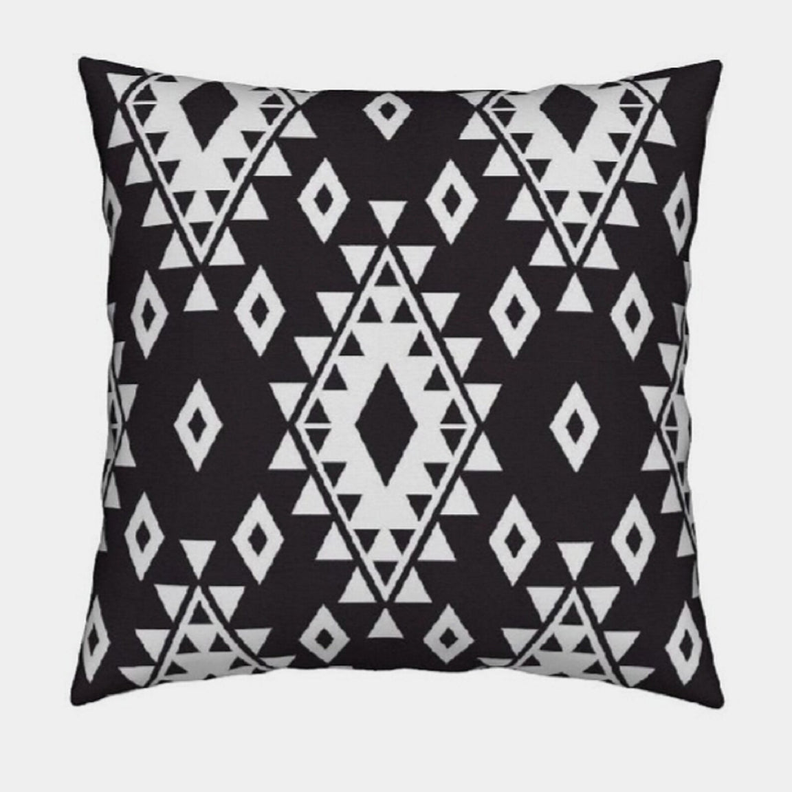 Black cushion cover with white diamonds and rows of small triangles.
