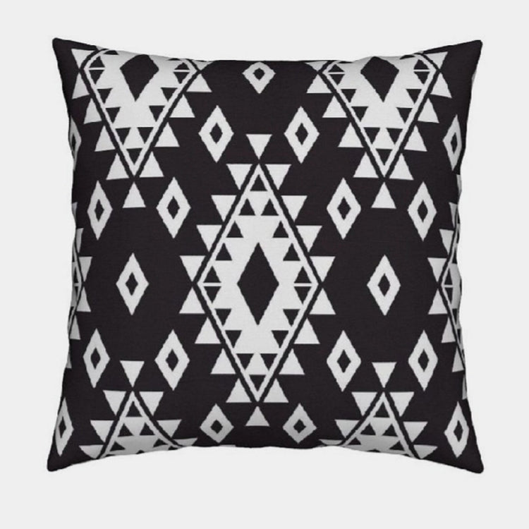 Black cushion cover with white diamonds and rows of small triangles.