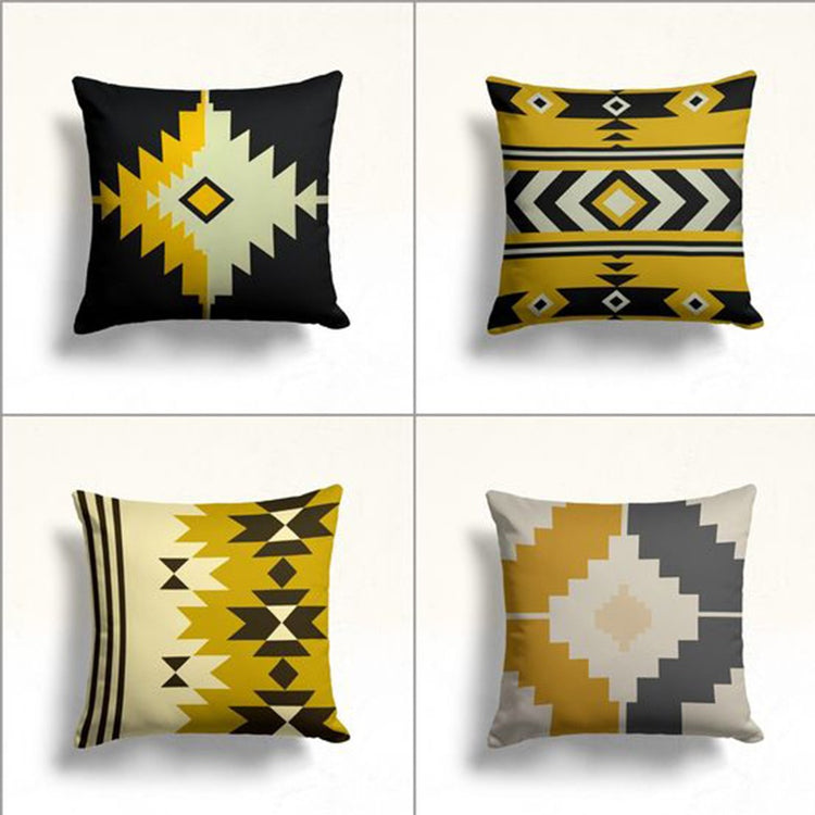 Four mustard, black, grey and cream cushion covers with bold geometric motifs.