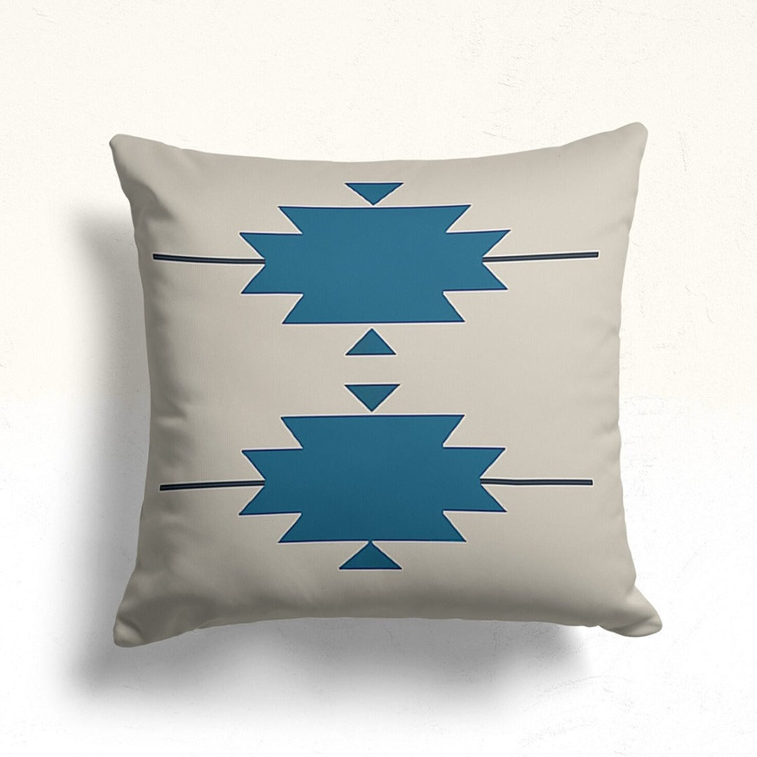 Cream cushion cover with two teal stepped geometric motifs.