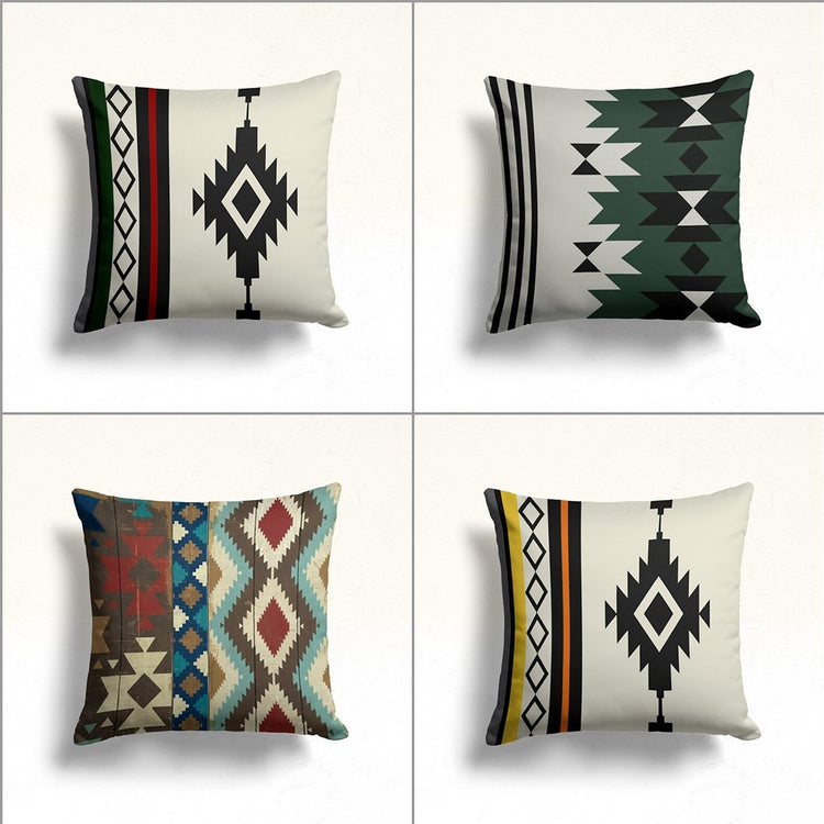 Four cream cushion covers with green, black and earthy geometric designs.