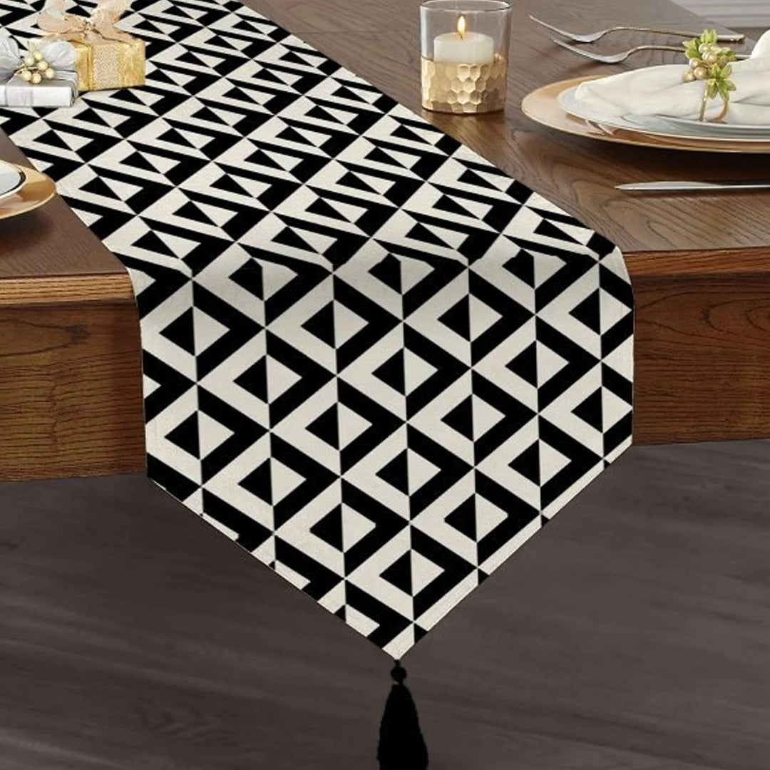 Black and white triangular geometric table runner with a tasselled end.