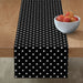 Black table runner with small white polka dots.