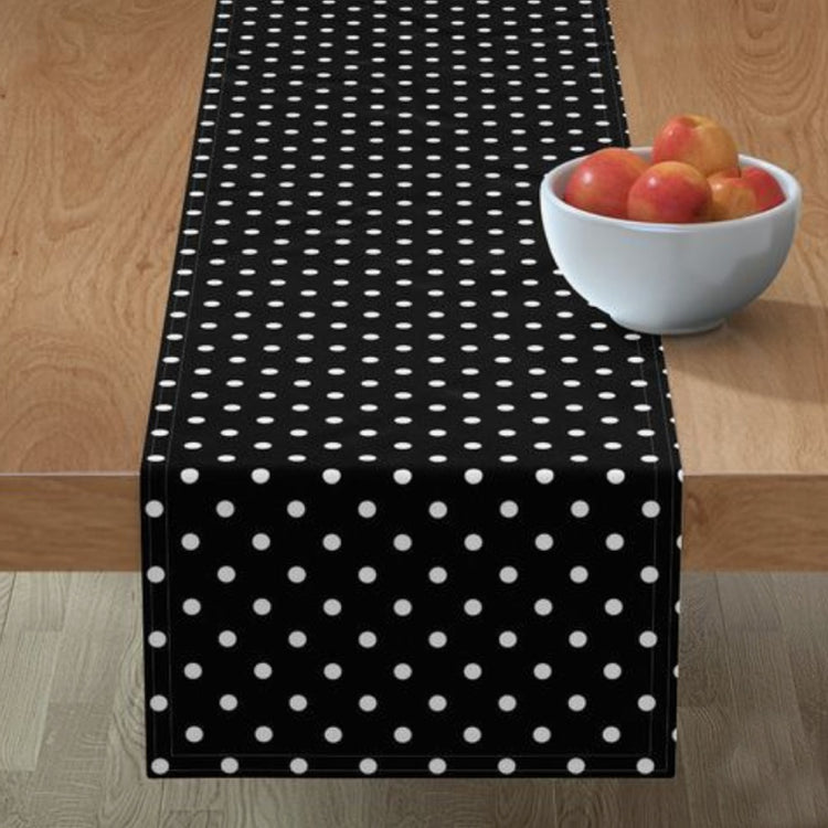 Black table runner with small white polka dots.