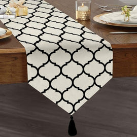 White table runner with black trellis lines and a tasselled end.