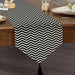 Black and white narrow-chevron table runner with a tasselled end.
