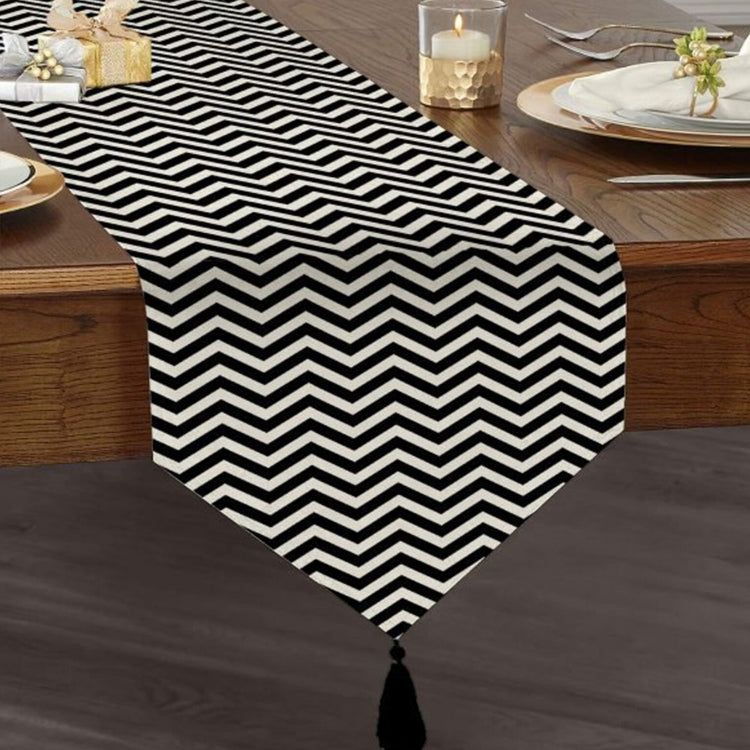Black and white narrow-chevron table runner with a tasselled end.