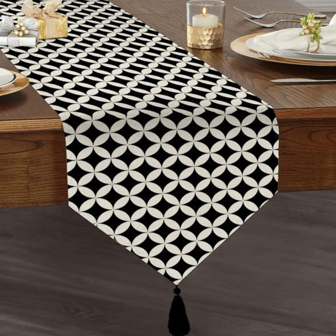 Black and white geometric lattice table runner with a tasselled end.