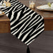 Black and white zebra-stripe table runner with a tasselled end.