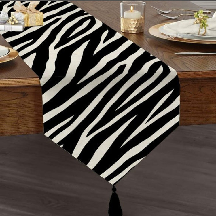 Black and white zebra-stripe table runner with a tasselled end.