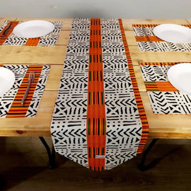 Black and white geometric table runner with an orange centre stripe and matching placemats.