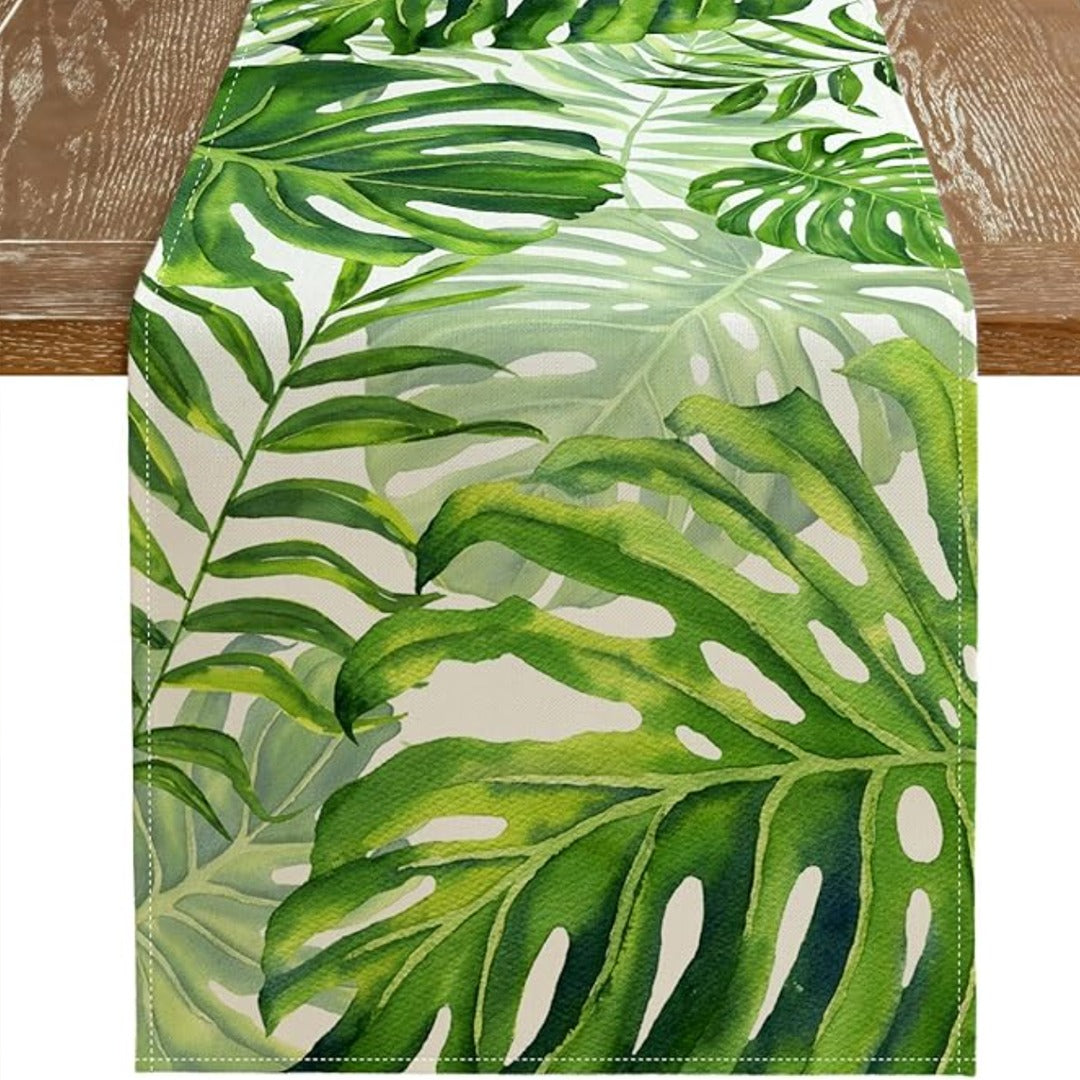 Close-up of green tropical-leaf motifs on a white table runner