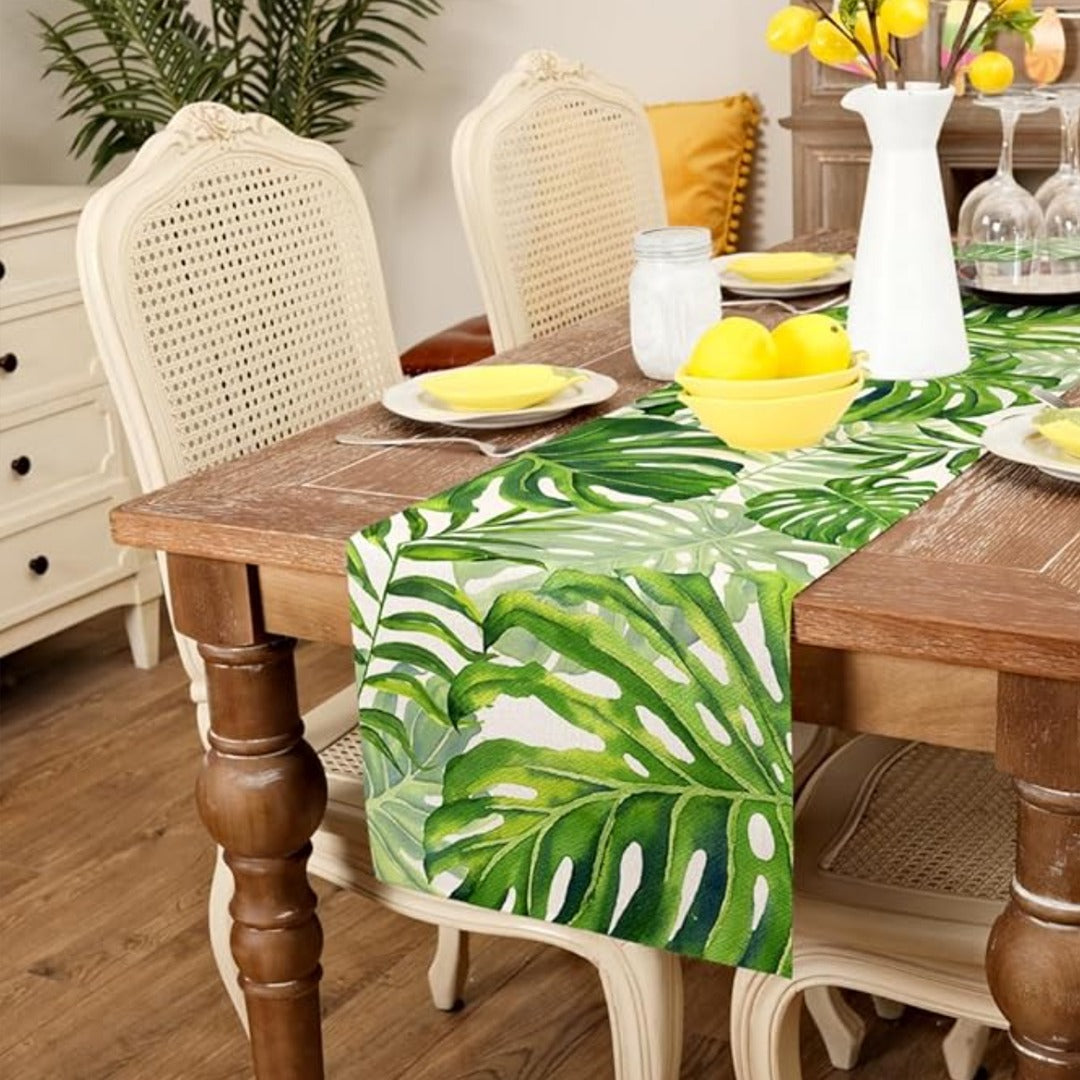 Green tropical-leaf table runner displayed on a wooden dining table
