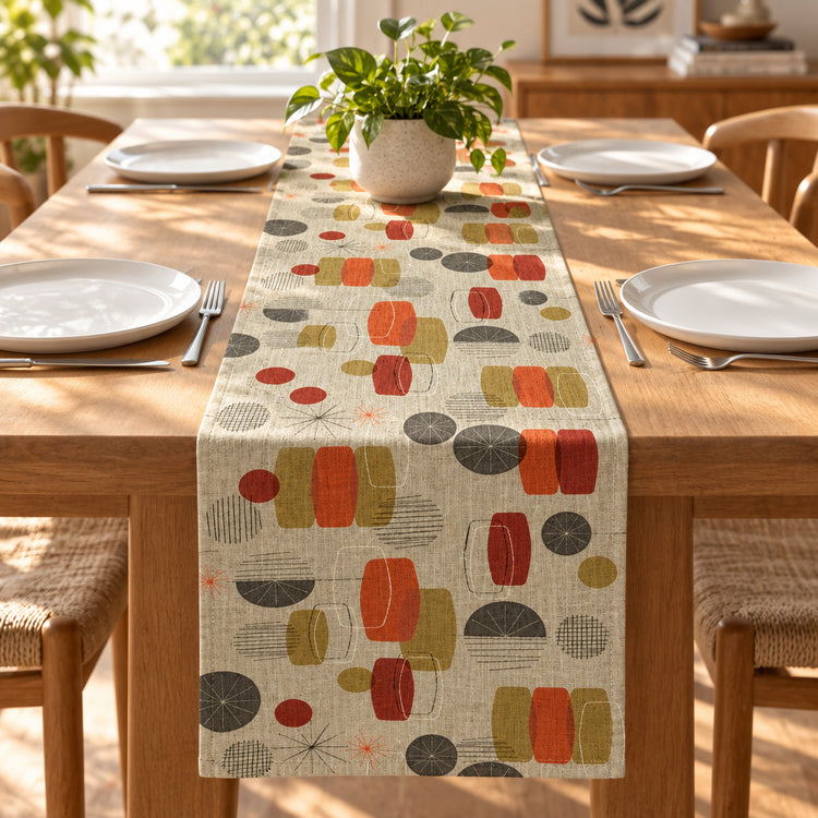 Beige table runner with scattered abstract shapes in grey, orange and black.