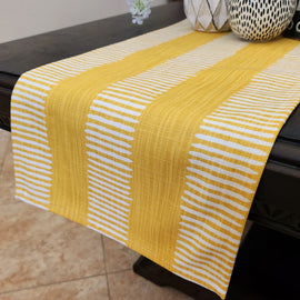 Yellow and white striped table runner on a dark table.