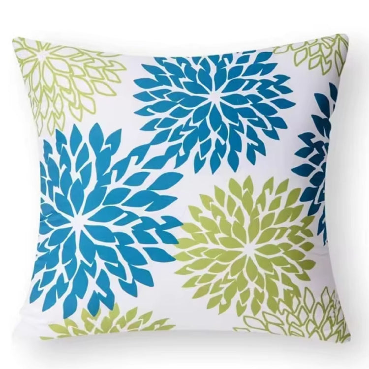 White cushion cover with large blue and green chrysanthemum-like flowers.