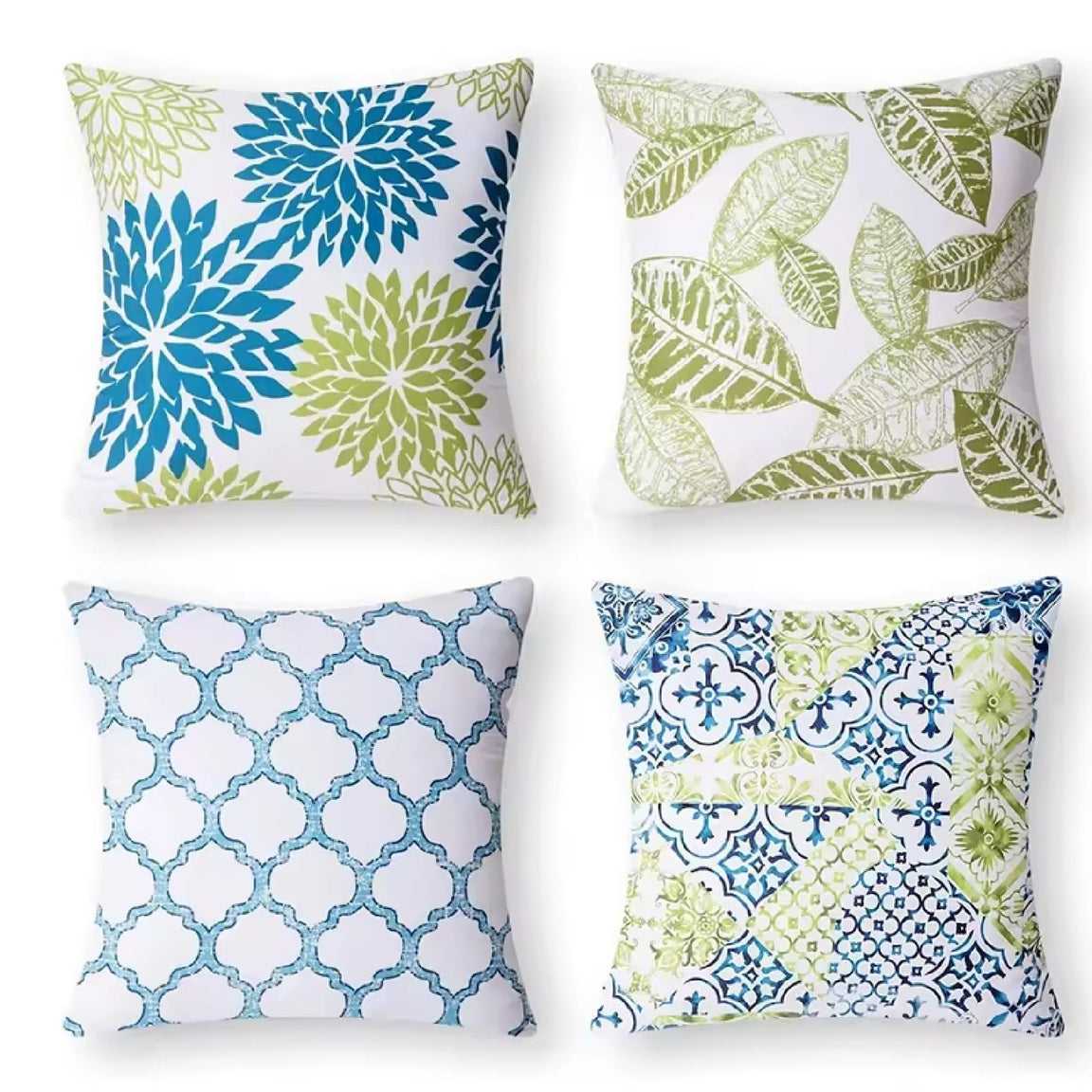 Four white cushion covers with blue and green floral, leaf and lattice patterns.