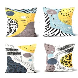 Four cushion covers with yellow, pale blue, grey and black abstract animal-print panels.