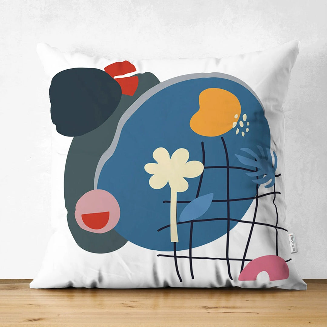 Cream cushion cover with a large blue shape, small flowers and fine black lines.