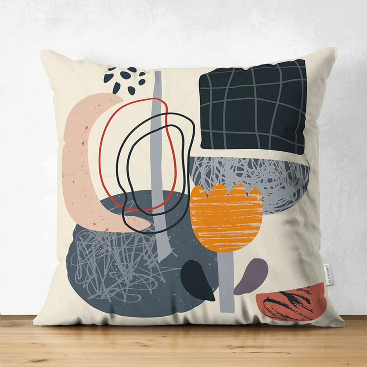 Cream cushion cover with orange flowers, dark geometric panels and looping black lines.