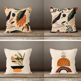 Four cream cushion covers with botanical and abstract earth-tone illustrations.