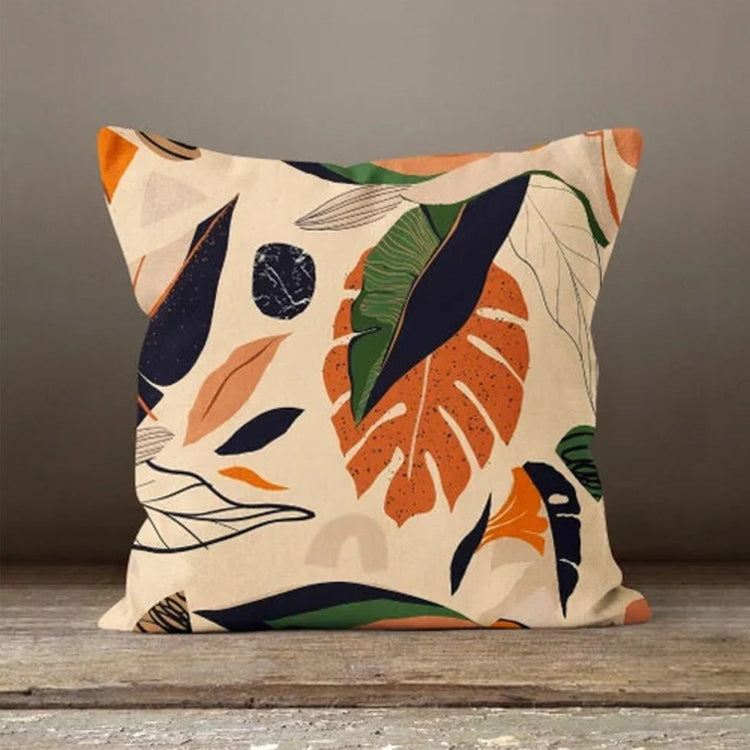 Cream cushion cover with large rust, green and navy leaves and fine branch outlines.