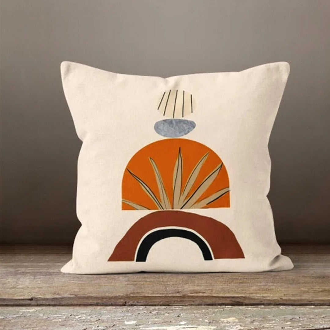 Cream cushion cover with stacked orange, rust and black arches and a delicate leaf outline.