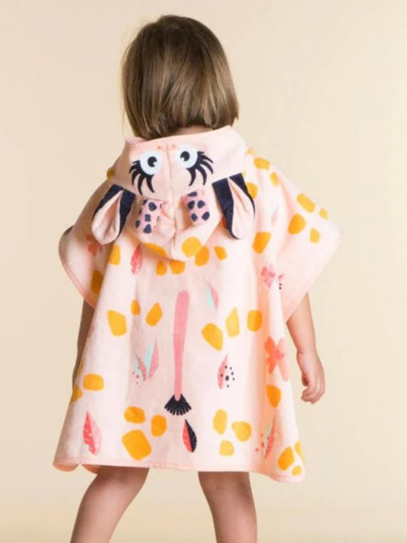 Back view of a child wearing a peach giraffe-pattern towel poncho.